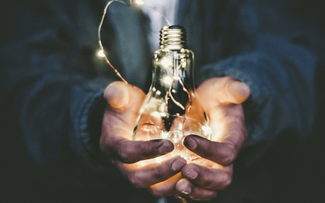 generic image of a man holding a lightbulb filled with twinkle lights